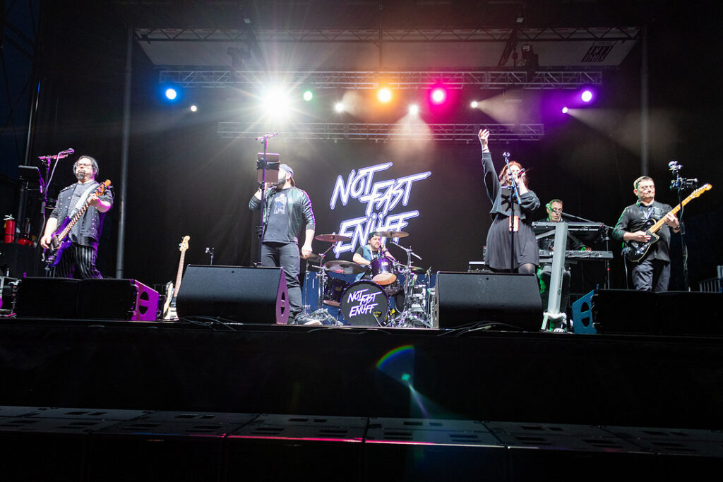 A band performs under concert lighting on the Farewell Festival main stage at night