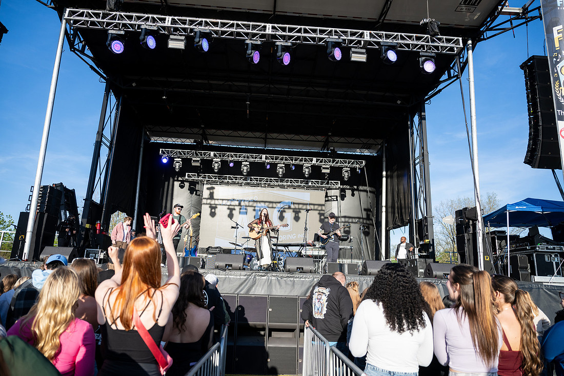 A band plays on the Farewell Festival main stage beside a flown line array