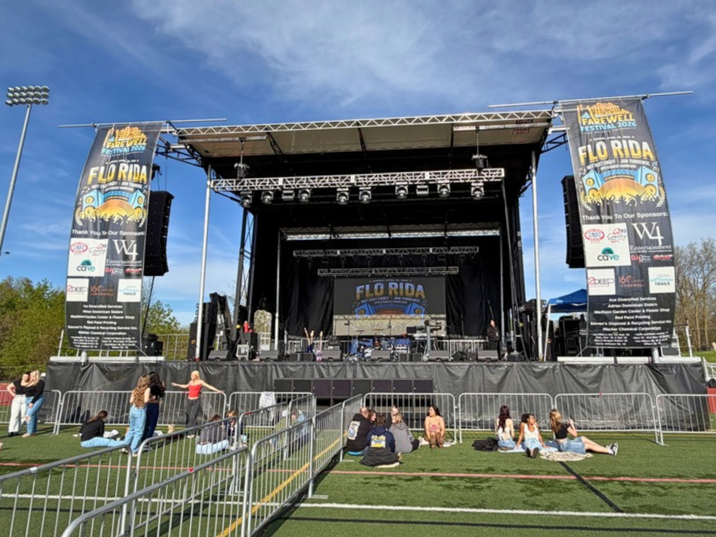 Concert stage with flown line arrays and Farewell Festival banners naming Flo Rida, at O'Laughlin Stadium before doors
