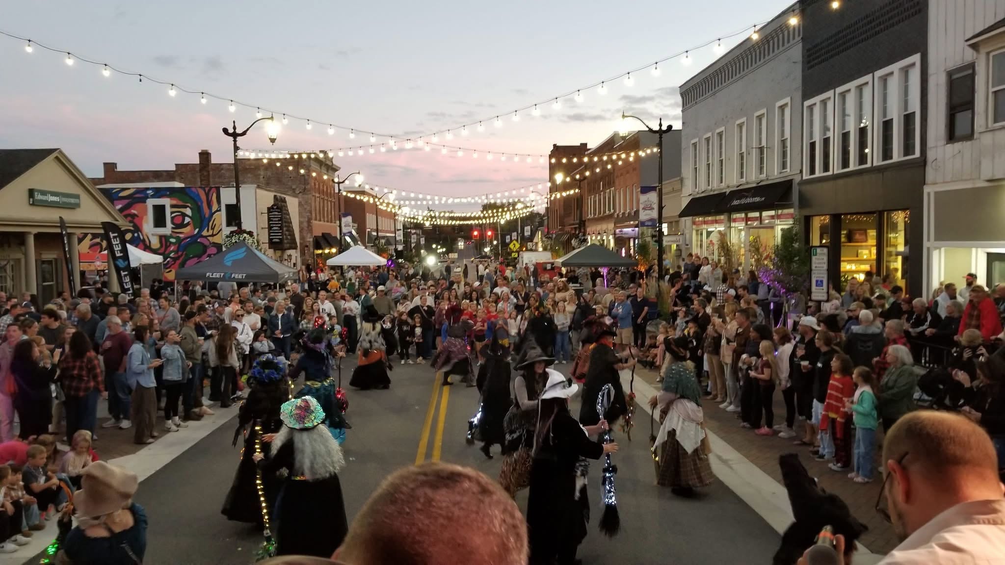 Crowd filling a downtown street at dusk during a First Friday festival