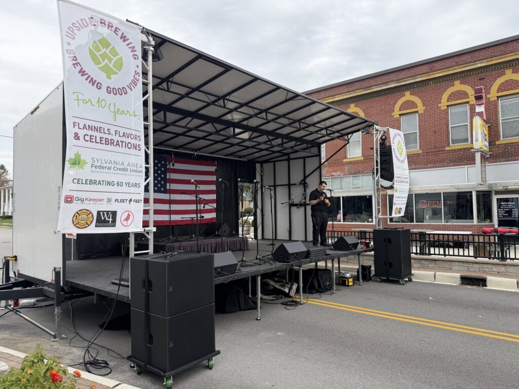 Groovy Event Rentals mobile stage on a downtown street with sponsor banners on both sides