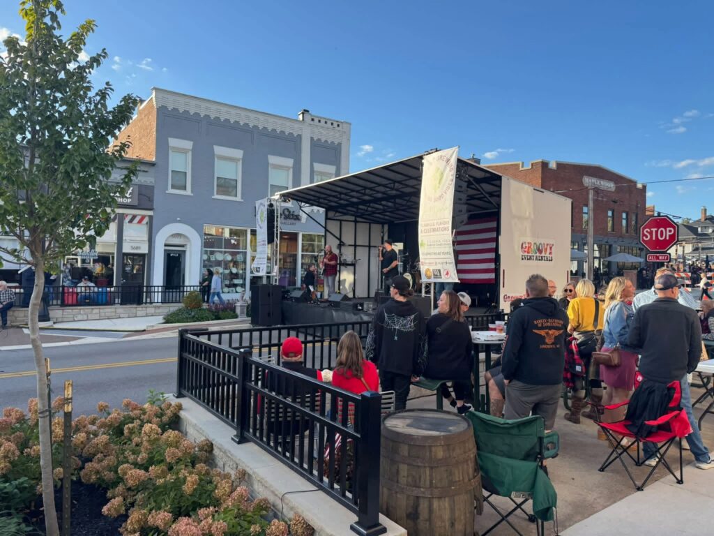 Audience seated in front of the mobile stage on a downtown street