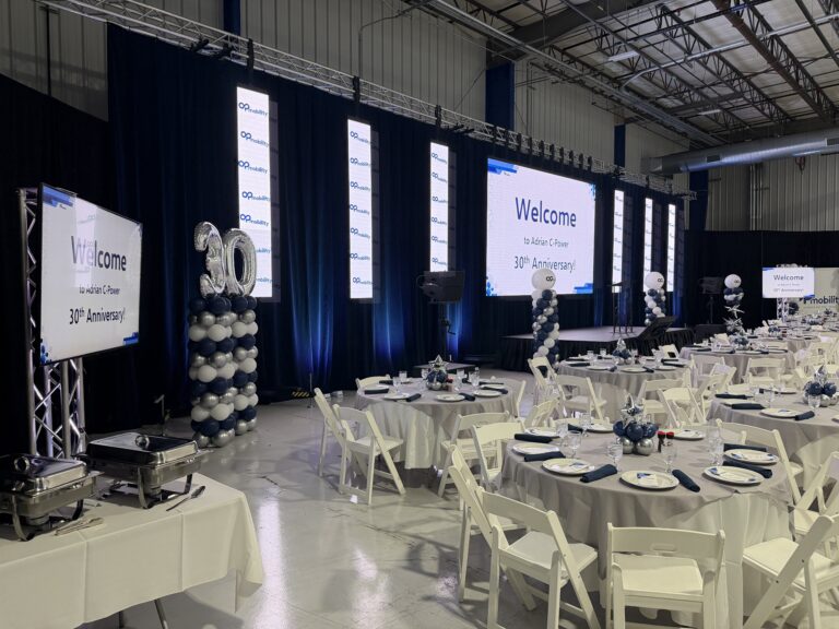 Relay screen on a truss stand beside LED columns and a balloon column shaped like the number 30